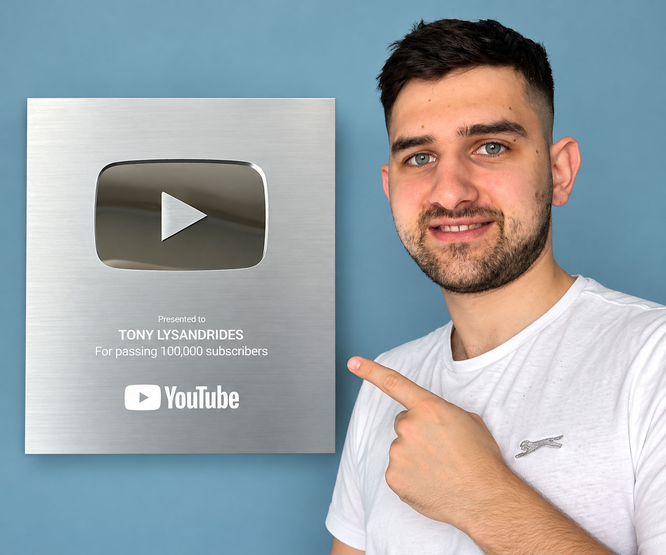 Tony Lysandrides pointing to his YouTube Silver Play Button for passing 100,000 subscribers
